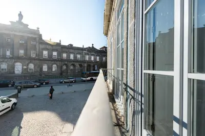 a person standing outside of a building looking out of a window at Blue House Porto Apartments - Parking in Porto