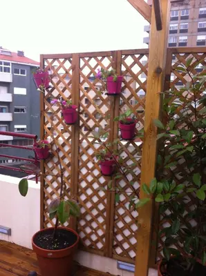 a wooden fence with potted plants on a balcony at Apartment Garden Music in Porto