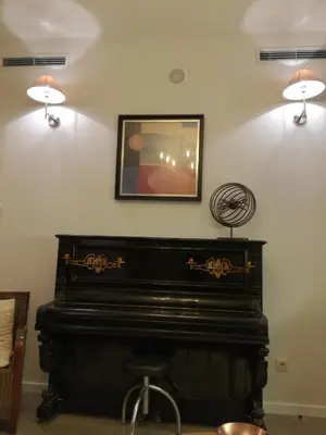 a black piano in a room with two lights on the wall at Apartment Garden Music in Porto