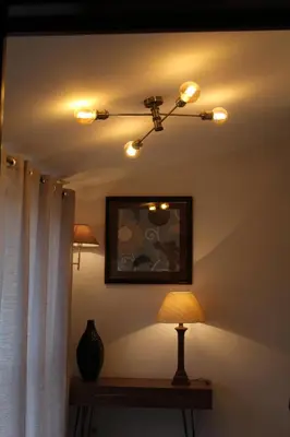 a room with a ceiling light and a table with a lamp at Apartment Garden Music in Porto