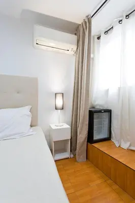 a bedroom with a bed and a tv and a window at Braganca Oporto in Porto