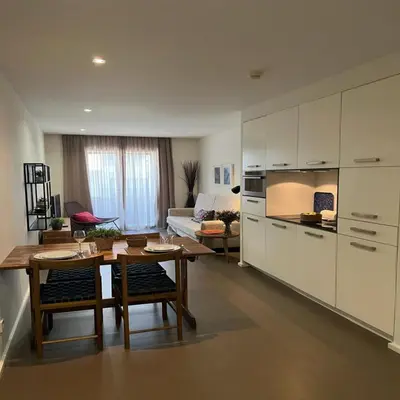 a kitchen and living room with a table and a couch at bnapartments Palacio in Porto