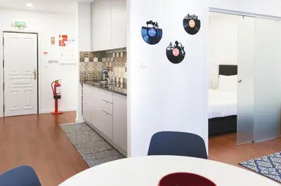 a room with a table and chairs and a bed at APOSENTUS - Your Home in Martires da Liberdade in Porto