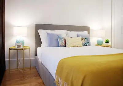 a bedroom with a large white bed with colorful pillows at HM - Carlos Alberto Apartment 2 in Porto