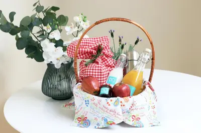 a basket of fruit and drinks on a table with a vase at HM - Carlos Alberto Apartment 2 in Porto
