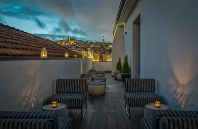 a rooftop patio with chairs and tables and a city at 296 Heritage Apartments in Vila Nova de Gaia