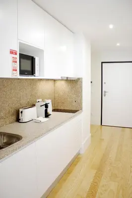a kitchen with white cabinets and a counter top at HM - Carlos Alberto Apartment 3 in Porto