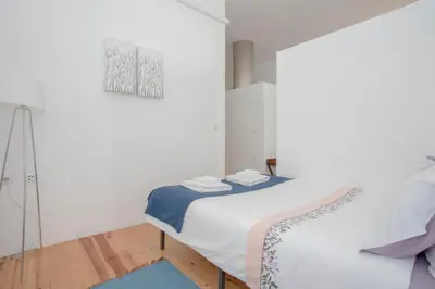 a white bedroom with a bed and a mirror at Liiiving In Porto | Bolhão Market Apartments in Porto