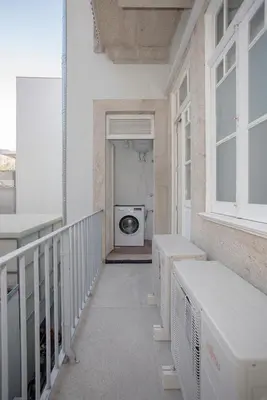a balcony with a washing machine in a building at Liiiving In Porto | Bolhão Market Apartments in Porto