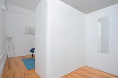 a living room with white walls and a blue rug at Liiiving In Porto | Bolhão Market Apartments in Porto