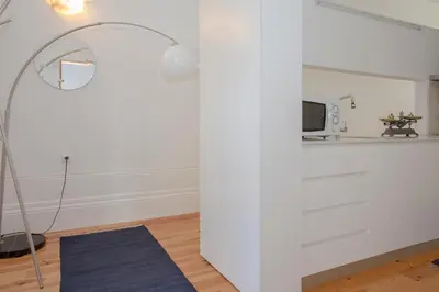 a white room with a floor lamp and a white wall at Liiiving In Porto | Bolhão Market Apartments in Porto