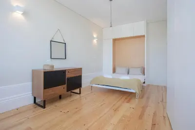 a bedroom with a bed and a dresser in it at Liiiving In Porto | Bolhão Market Apartments in Porto