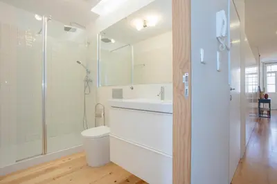 a white bathroom with a toilet and a shower at Liiiving In Porto | Bolhão Market Apartments in Porto