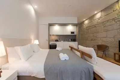 a bedroom with a large bed with two towels on it at LovelyStay - Rico's Apartment - Almada 1ºF in Porto