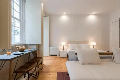 a bedroom with a bed and a table and a couch at LovelyStay - Rico's Apartment - Almada 1ºF in Porto