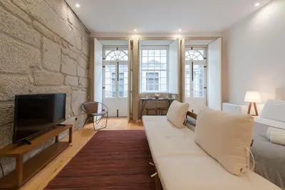 a living room with a white couch and a tv at LovelyStay - Rico's Apartment - Almada 1ºF in Porto