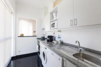 a kitchen with white cabinets and a sink at Gaia Metro-2 Bedrooms in Vila Nova de Gaia