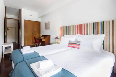 a bedroom with a large white bed and a chair at Cozy Stay - Cedofeita 436 in Porto