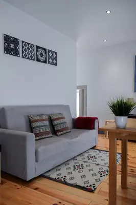 a living room with a gray couch and a table at Aurora Garden in Porto