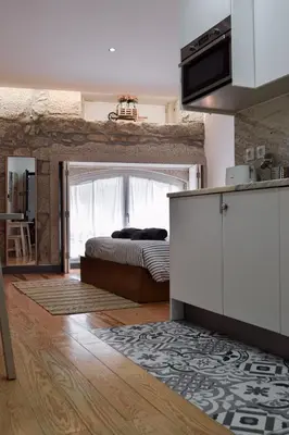 a room with a bed and a kitchen with a kitchen gmaxwell gmaxwell gmaxwell at Aurora Street in Porto