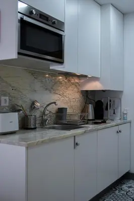 a white kitchen with a sink and a microwave at Aurora Street in Porto