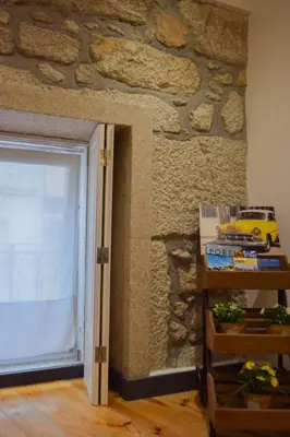 a room with a stone wall and a door with a toy car at Aurora Sky in Porto