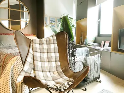 a bedroom with a chair with a blanket on it at HOMEinTOWN Camões - Modern and Quiet Central Studio - AC & Fast WiFi Near Trindade Metro Station in Porto