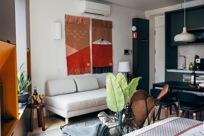 a living room with a white couch and a table at HOMEinTOWN Camões - Modern and Quiet Central Studio - AC & Fast WiFi Near Trindade Metro Station in Porto
