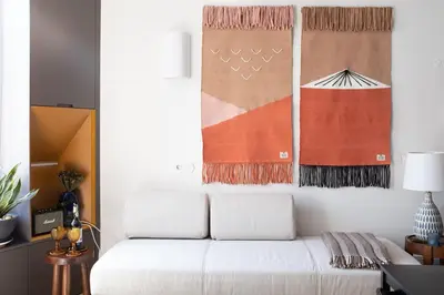 a living room with a white couch and art on the wall at HOMEinTOWN Camões - Modern and Quiet Central Studio - AC & Fast WiFi Near Trindade Metro Station in Porto