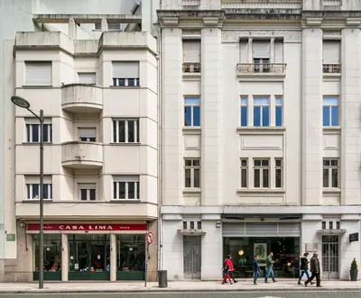 a white building with people walking in front of it at ALQUIMIA DOS ALIADOS - Gorgeous Palace Apartment in Porto