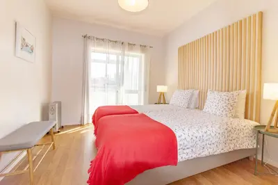 a bedroom with a large bed with a red blanket at Cedofeita 408, Green in Porto