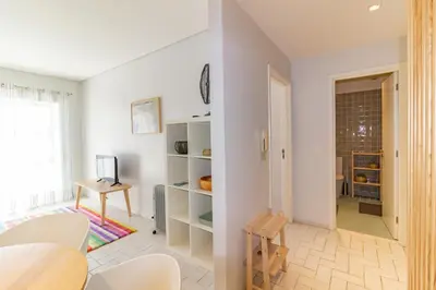 a living room with white walls and a table and chairs at Cedofeita 408, Green in Porto
