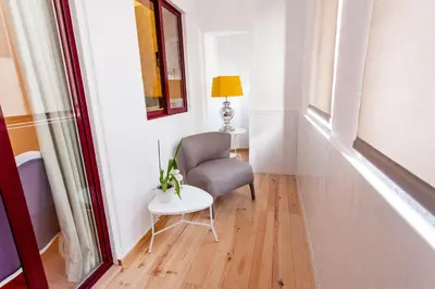 a living room with a chair and a table at Oporto City View - Santo Ildefonso Lovely in Porto