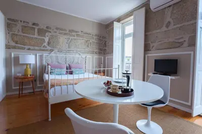 a living room with a white table and a bed at Oporto City View - Santo Ildefonso Lovely in Porto