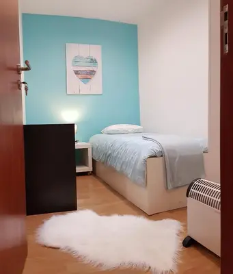 a bedroom with a bed and a blue wall at O Ninho in Vila Nova de Gaia