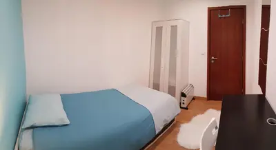 a bedroom with a blue bed and a desk and a door at O Ninho in Vila Nova de Gaia