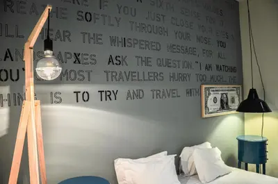 a bedroom with a bed with a sign on the wall at The Poets Inn in Porto