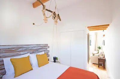 a bedroom with a bed with yellow and orange pillows at Bonfim Apartment in Porto