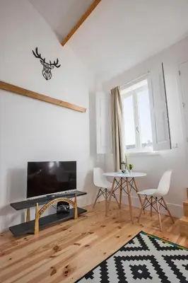 a living room with a table and a fireplace at Bonfim Apartment in Porto