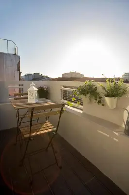 a small table on a balcony with plants on it at Bonfim Apartment in Porto