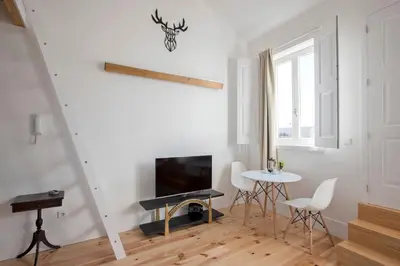 a living room with a tv and a table and chairs at Bonfim Apartment in Porto
