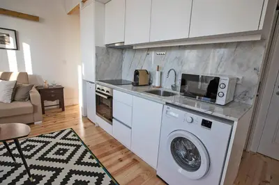 a kitchen with a washing machine and a microwave at Bonfim Apartment in Porto
