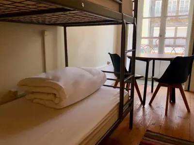 a bedroom with a bunk bed with a table and chairs at Porto Republica Downtown in Porto