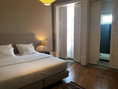 a bedroom with a large white bed and a window at Porto Republica Downtown in Porto