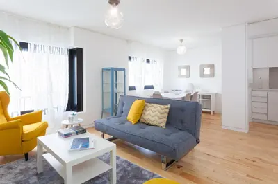 a living room with a blue couch and a yellow chair at Urban Views Townhouse Infante in Porto