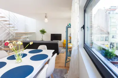 a dining room with a table and a large window at Urban Views Townhouse Arrábida in Porto