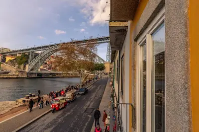 a group of people walking on a street next to a bridge at YOUROPO - Ribeira Gaia in Vila Nova de Gaia