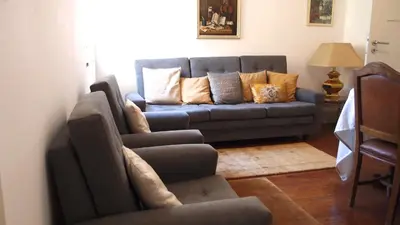 a living room with a blue couch with pillows at BS Villas Porto in Porto