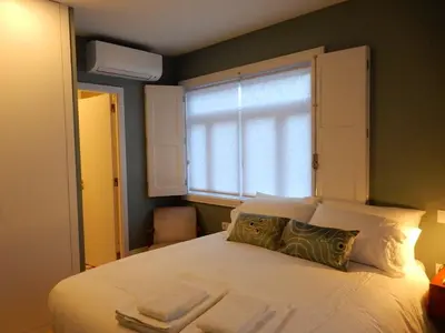 a bedroom with a large white bed with a window at Porto Traveler Apartment in Porto