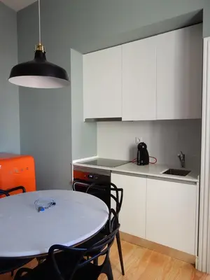 a kitchen with a table and white cabinets at Porto Traveler Apartment in Porto